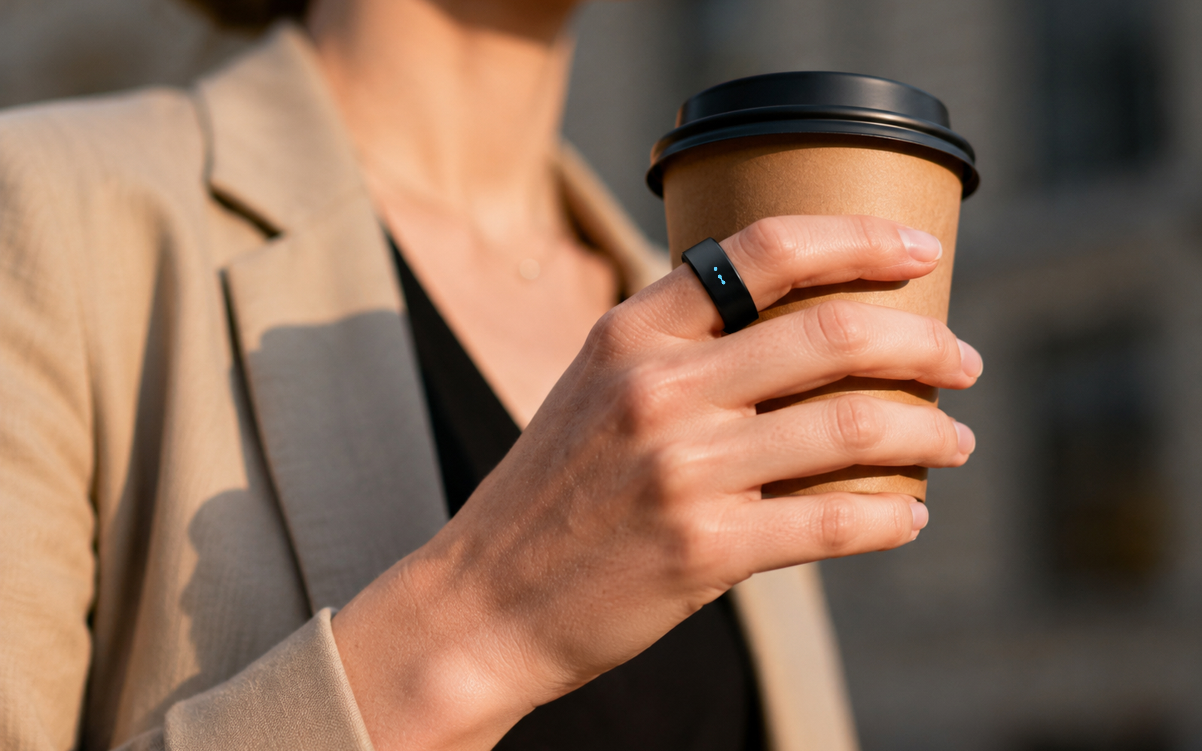 Person holding a coffee cup outdoors, wearing the USAY Ring